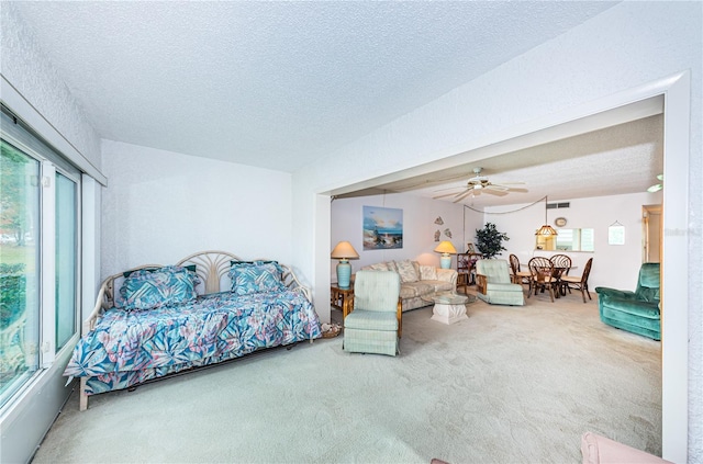 carpeted living room with a textured ceiling and ceiling fan