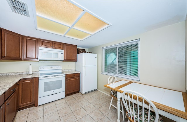 kitchen with light tile floors and white appliances