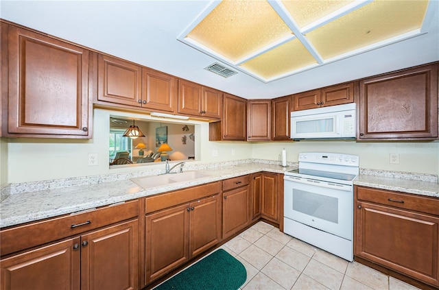 kitchen featuring light tile floors, light stone countertops, white appliances, and sink