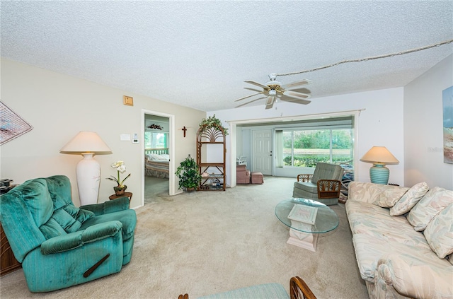 carpeted living room with a textured ceiling and ceiling fan