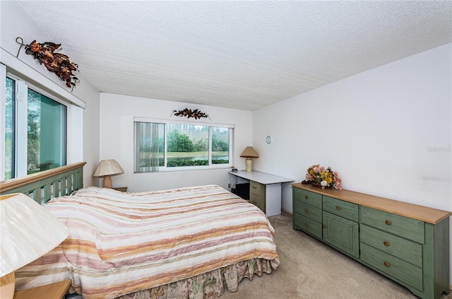 bedroom featuring light carpet and a textured ceiling