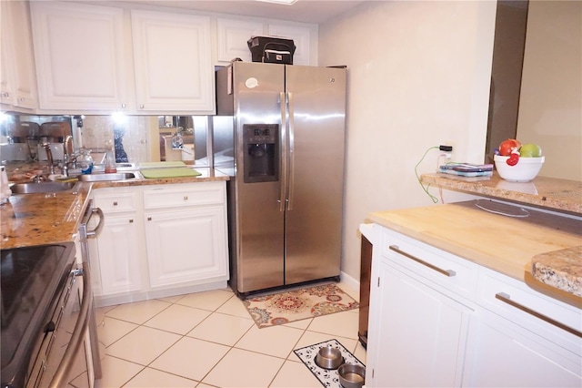 kitchen featuring light tile patterned floors, stainless steel appliances, white cabinetry, and sink