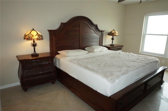 bedroom with ceiling fan and light tile patterned floors