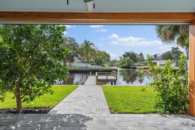 view of dock featuring a water view and a yard