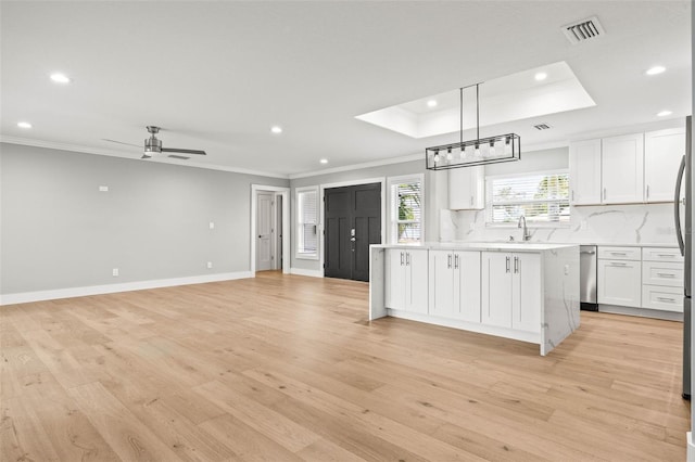 kitchen with light wood finished floors, tasteful backsplash, visible vents, white cabinets, and light countertops