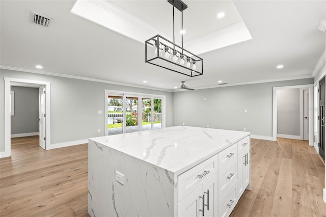 kitchen featuring a center island, visible vents, crown molding, and light wood finished floors