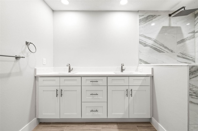 full bathroom with wood tiled floor, a sink, and a marble finish shower