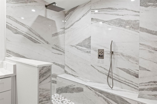 bathroom featuring vanity and a marble finish shower