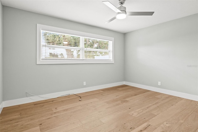 empty room with light wood-type flooring, a ceiling fan, and baseboards