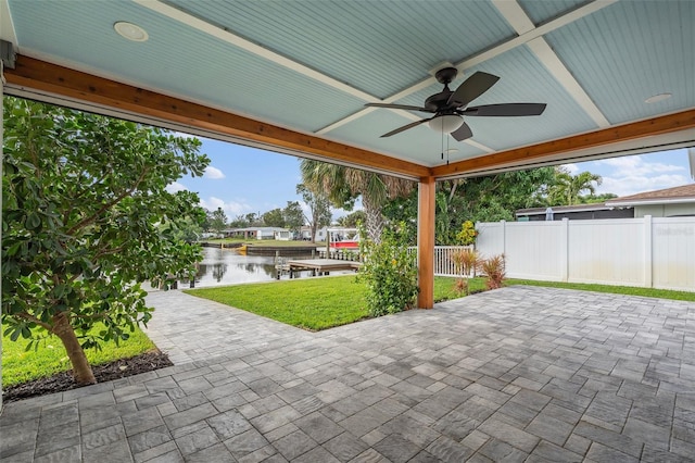 view of patio / terrace with a water view, fence, and a ceiling fan