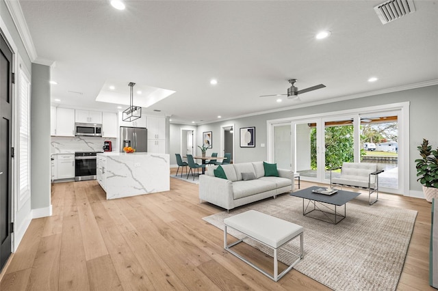 living area featuring light wood-type flooring, visible vents, crown molding, and recessed lighting