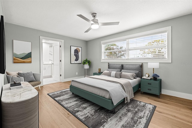 bedroom featuring baseboards, a ceiling fan, connected bathroom, light wood-style flooring, and a textured ceiling