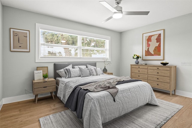 bedroom featuring a ceiling fan, light wood-type flooring, and baseboards