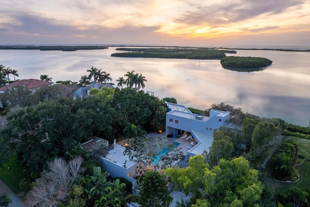 aerial view at dusk featuring a water view