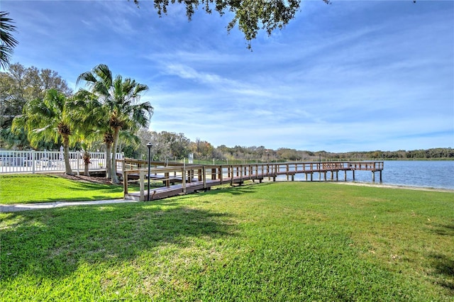 dock area with a water view and a yard