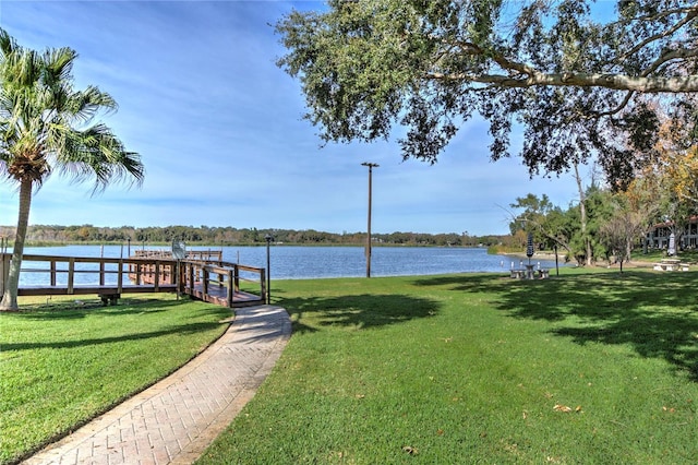 view of dock featuring a water view and a yard