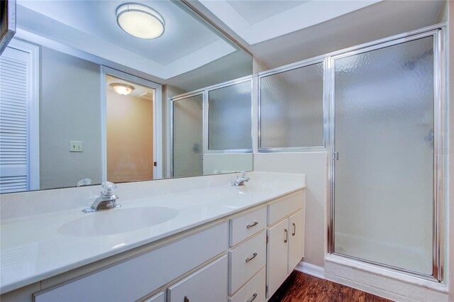 bathroom with walk in shower, wood-type flooring, and vanity