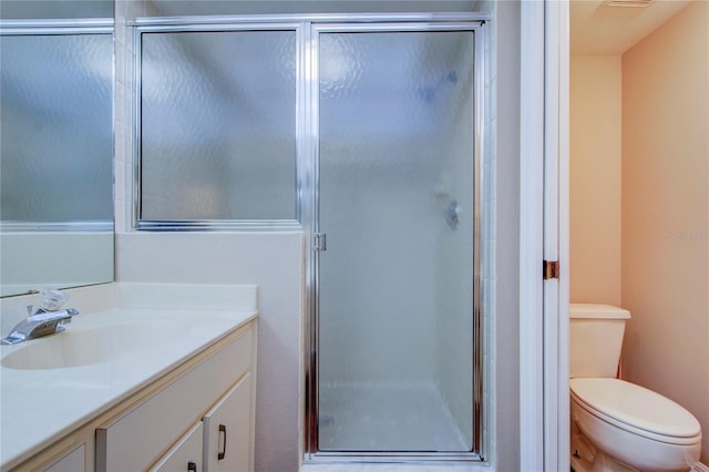 bathroom featuring walk in shower, vanity, and toilet