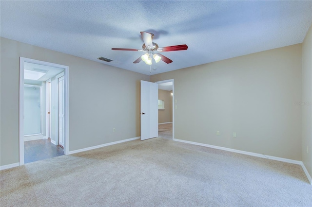 carpeted empty room featuring ceiling fan and a textured ceiling