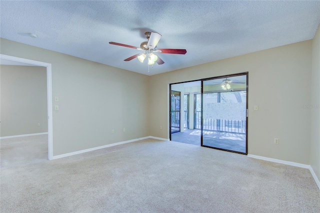 empty room featuring light colored carpet, a textured ceiling, and ceiling fan