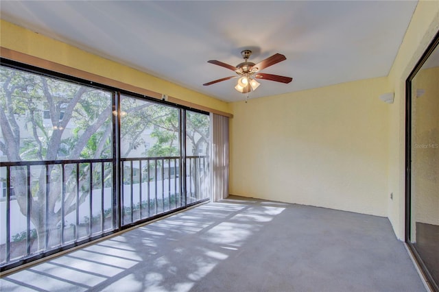 unfurnished sunroom featuring ceiling fan