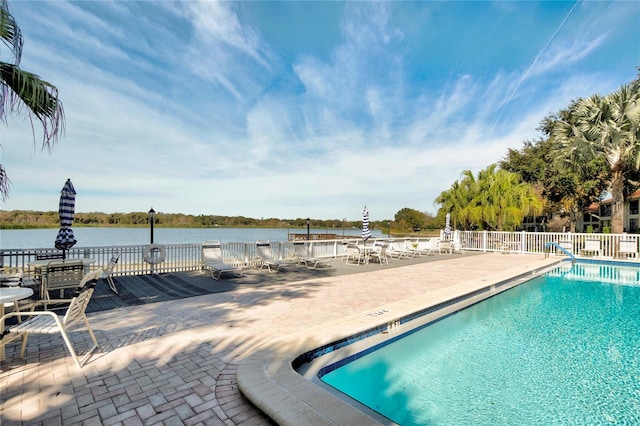 view of pool with a patio and a water view