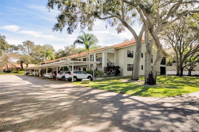 exterior space with a lawn and a carport