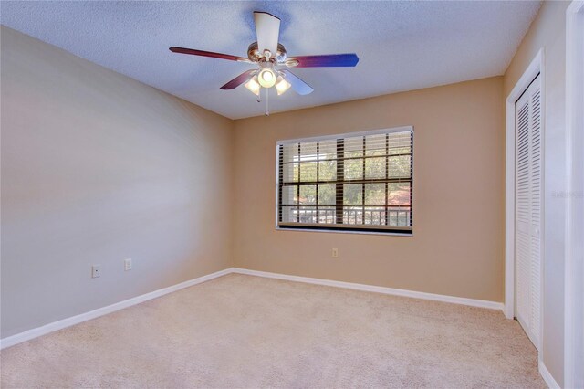 unfurnished bedroom featuring a textured ceiling, carpet, a closet, and ceiling fan