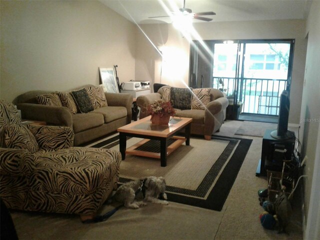 living room with lofted ceiling, carpet floors, a wood stove, and ceiling fan