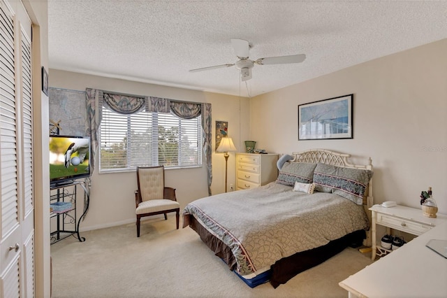 carpeted bedroom with a textured ceiling, a closet, and ceiling fan