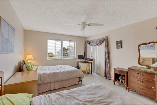 carpeted bedroom with ceiling fan and a textured ceiling