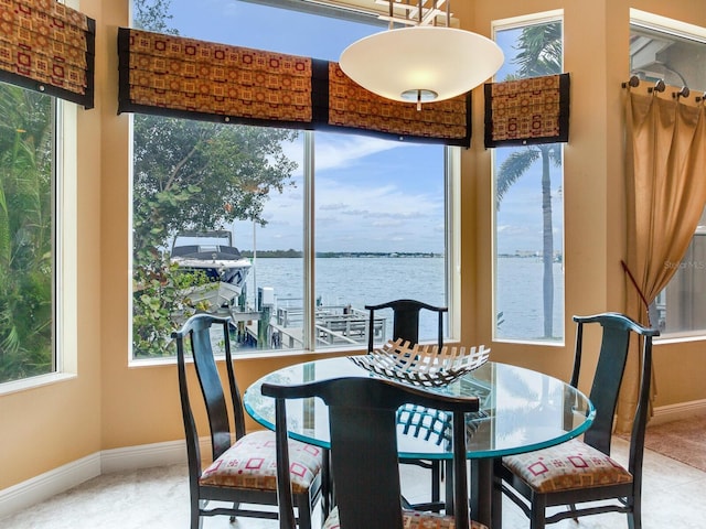 dining space with a water view and carpet