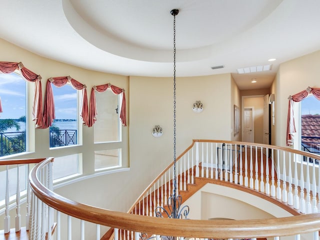 stairs featuring a raised ceiling