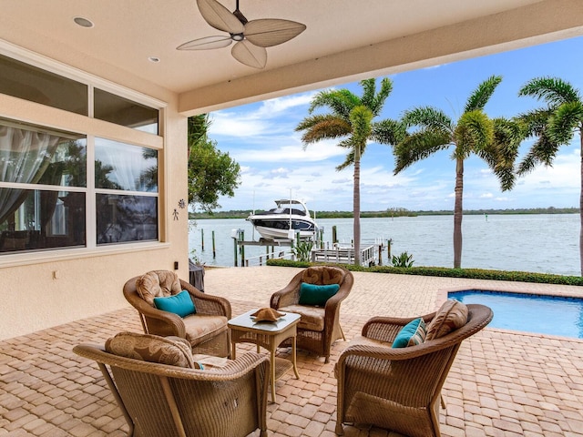 view of patio / terrace featuring ceiling fan, a boat dock, and a water view