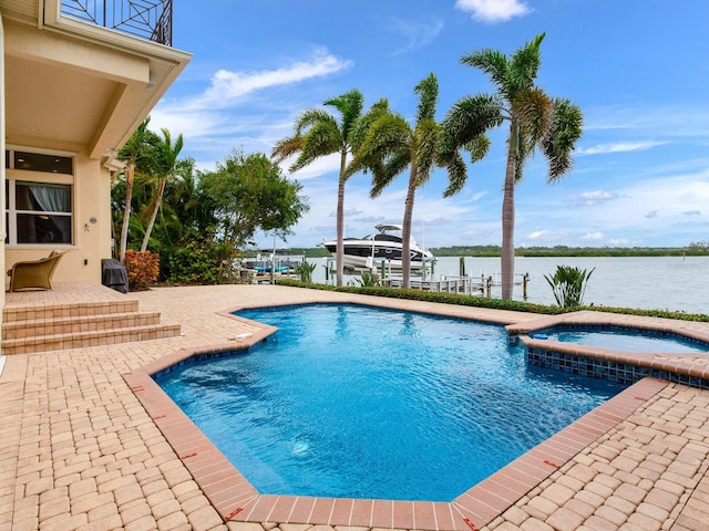 view of pool with a patio, an in ground hot tub, a boat dock, and a water view