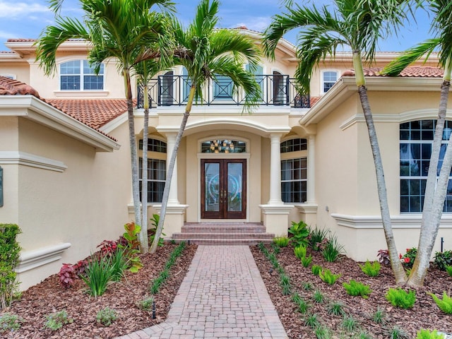 entrance to property featuring a balcony and french doors