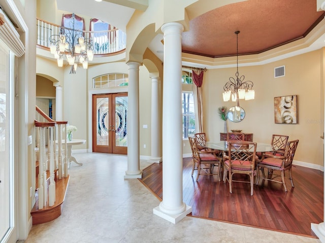 dining room with french doors, decorative columns, a chandelier, and a tray ceiling