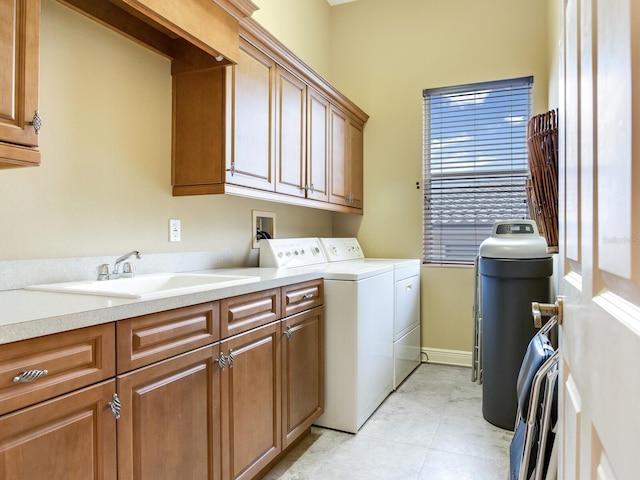 clothes washing area featuring sink, cabinets, independent washer and dryer, and light tile patterned floors