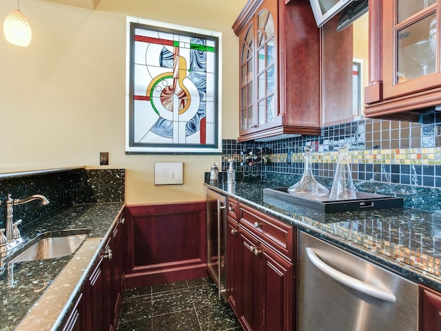 kitchen with sink, pendant lighting, dishwasher, and dark stone countertops