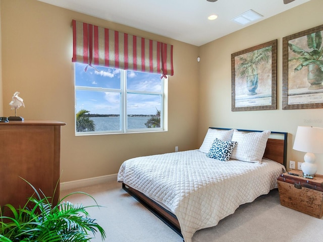 bedroom with a water view and carpet floors