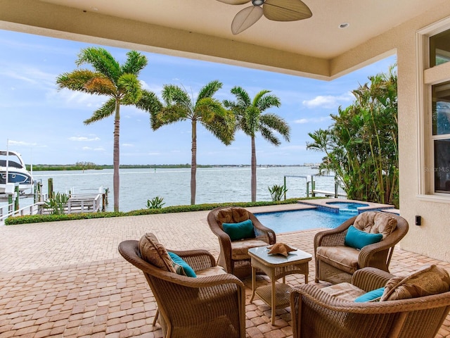 view of swimming pool featuring a patio, ceiling fan, an in ground hot tub, and a water view