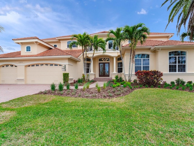 mediterranean / spanish-style home featuring french doors, a front yard, and a garage