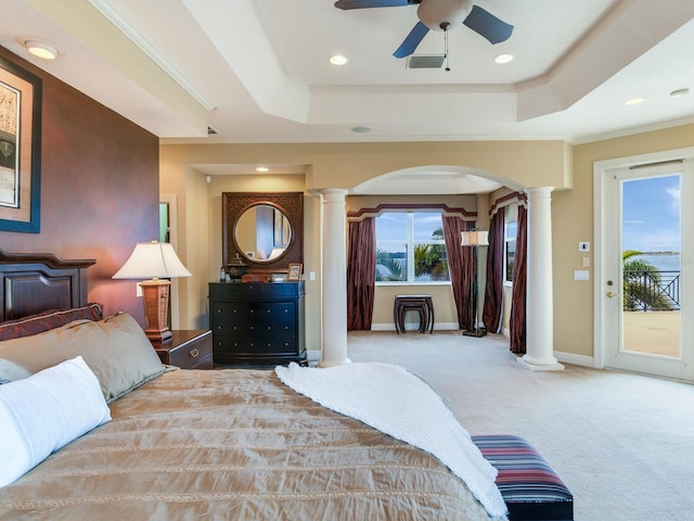 carpeted bedroom featuring access to outside, ceiling fan, a tray ceiling, and multiple windows