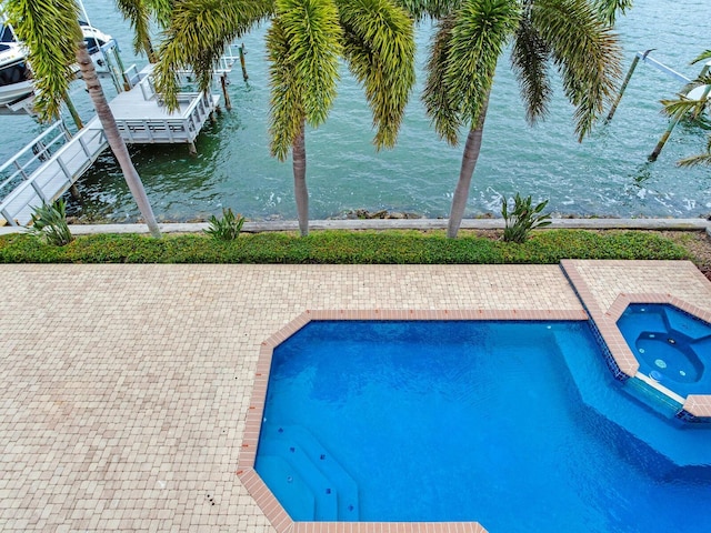 view of swimming pool with a patio, an in ground hot tub, and a water view