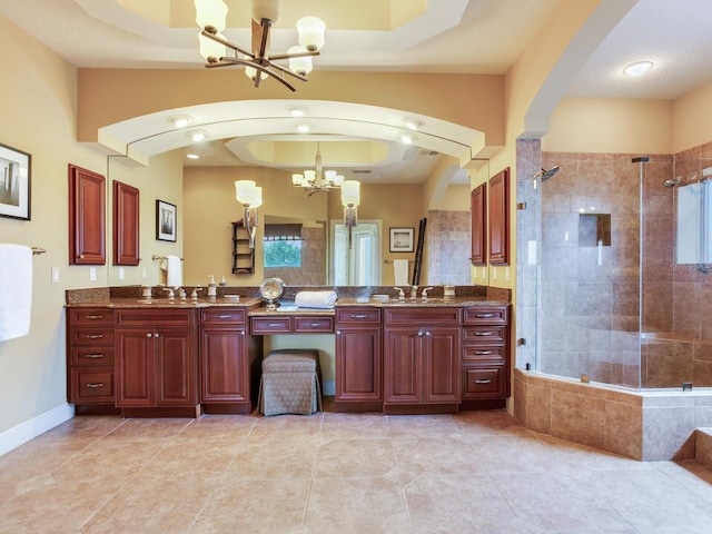 bathroom featuring tile patterned flooring, a chandelier, walk in shower, vanity, and a tray ceiling