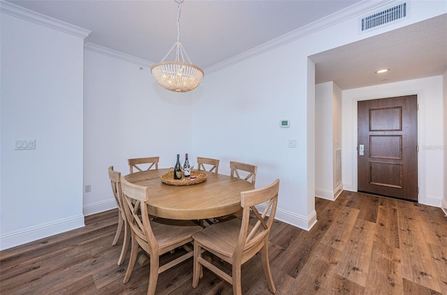 dining room featuring an inviting chandelier, crown molding, and dark hardwood / wood-style flooring