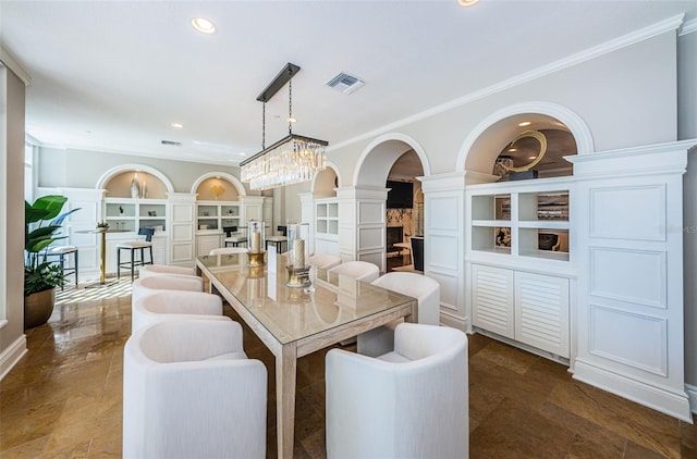 dining area with a chandelier, ornamental molding, built in shelves, dark tile floors, and decorative columns