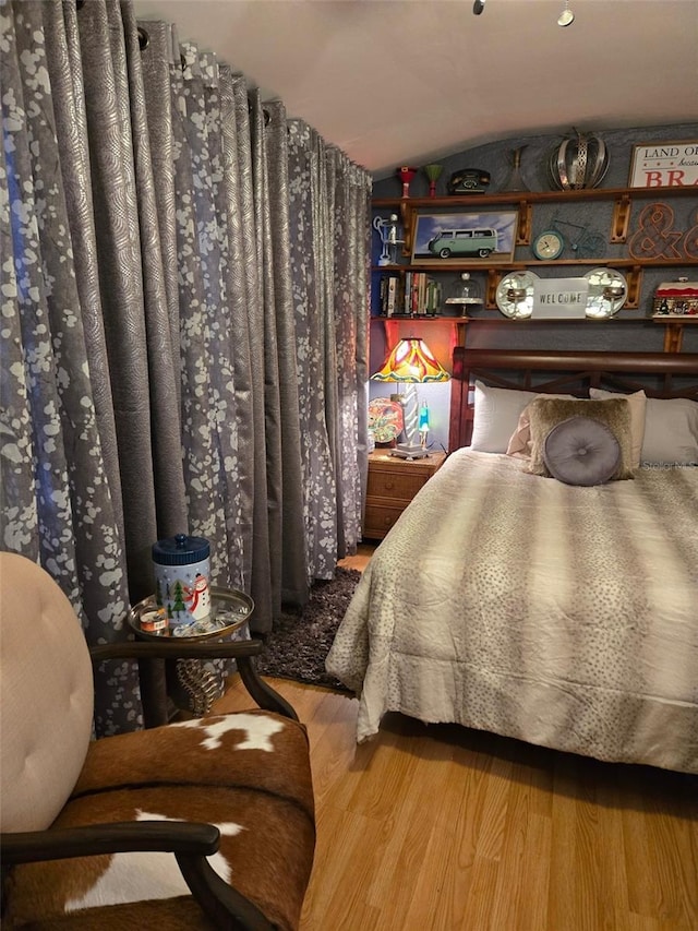 bedroom featuring hardwood / wood-style flooring and vaulted ceiling