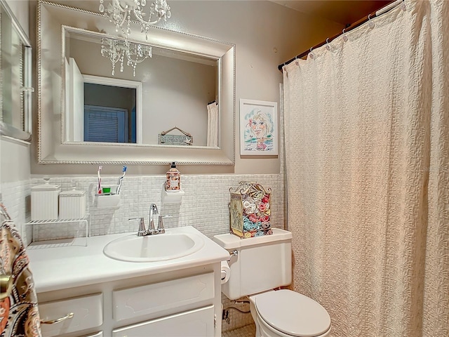 bathroom with vanity, toilet, and tile walls