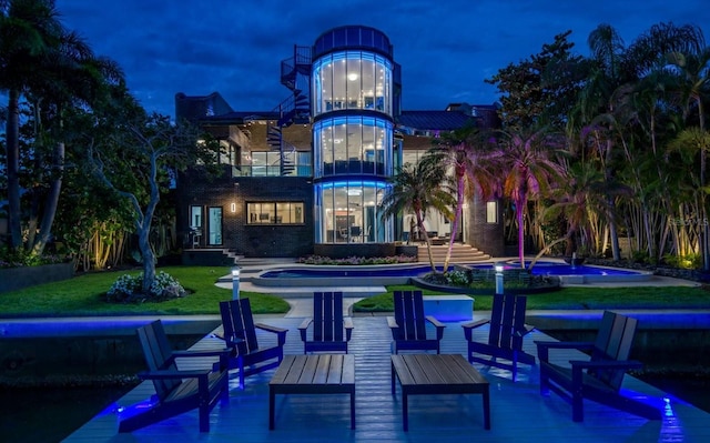 exterior space with an outdoor pool, a balcony, and a lawn